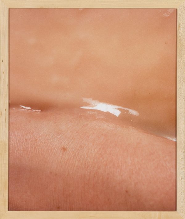 A framed picture of a shimmery liquid-like line in the middle of the crease of skin