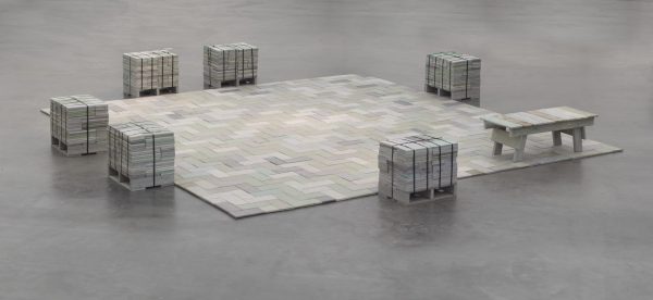 Six stools surround a square made up of various blocks on the floor with a bench at its bottom-right corner