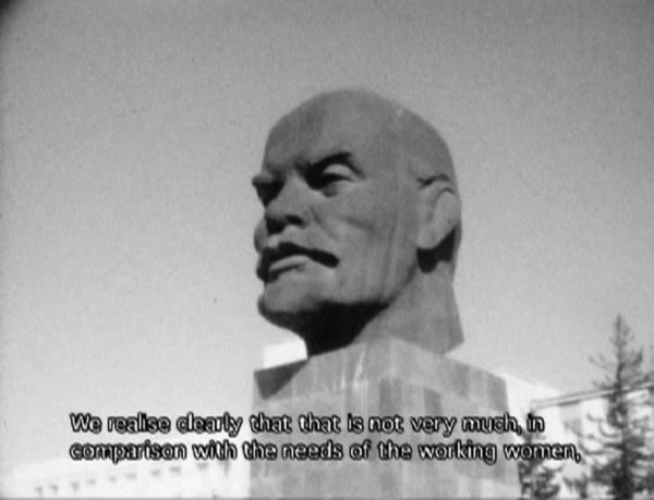 A black-and-white image still shows a large stone bust of Vladimir Lenin's head with closed caption text reading 