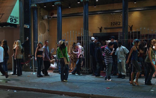 A group of people standing in front of a building with arched gates between pillars