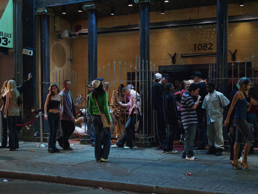 A group of people standing in front of a building with arched gates between pillars