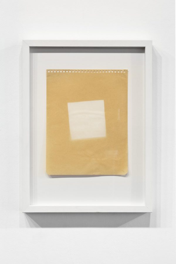 Framed piece of tan paper with a white square on it