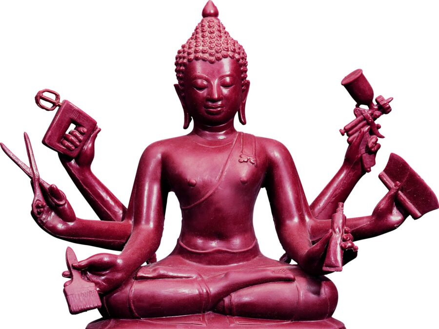 A rust colored buddist sculpture of a seated person with six hands holding in clockwise order, a paint spray gun, a large brush, a paint tube, a paint brush, scissors, and a hand-held mixer