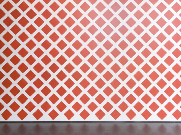 Red imperfect diamonds painted on a white wall