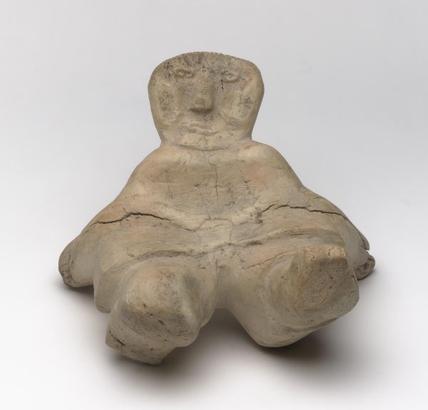 Sculpture of a human figure reclining. A crack goes through the middle.