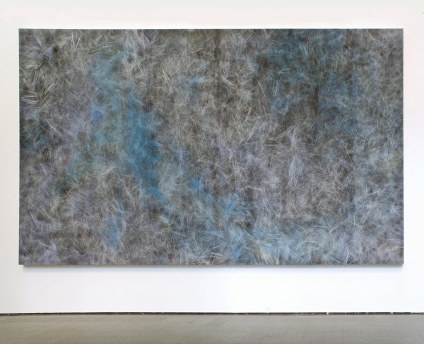 A large abstract artwork hanging on the wall featuring black and white lines accented by blue