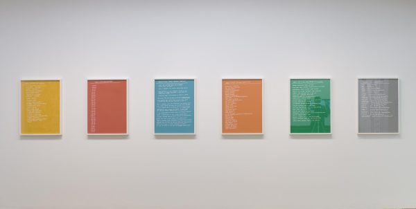 Six colorful artworks hang on a white wall