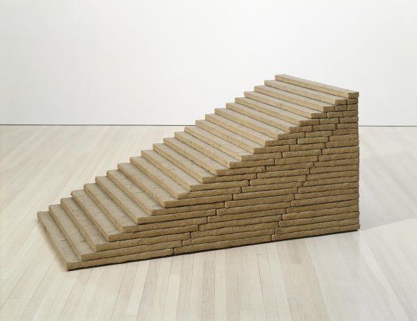 A light brown freestanding staircase on a wood floor.
