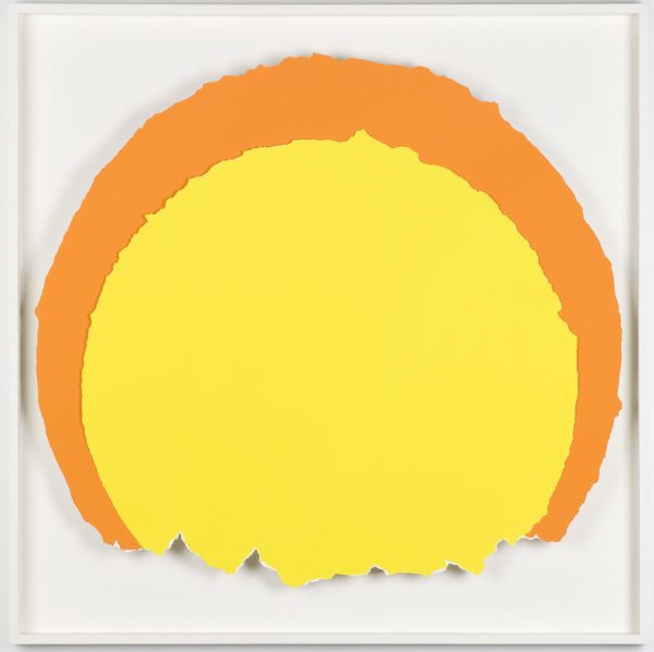 A yellow paper ripped into a circle in front of a larger ripped orange piece of paper that mirrors the yellow shape