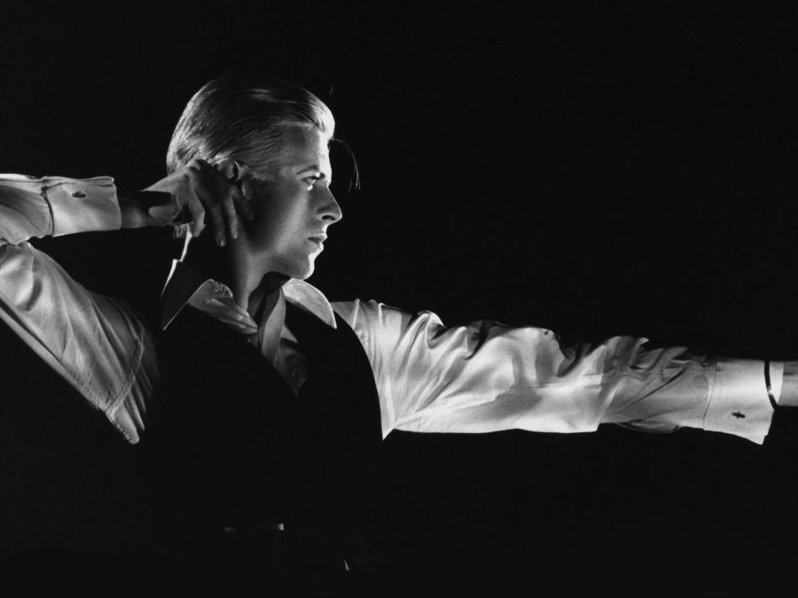 Black and white photo of David Bowie posing in an archer position