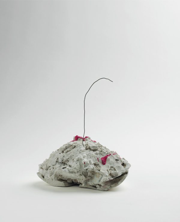 A pile of material with a single wire sticking out of it like a cherry stem