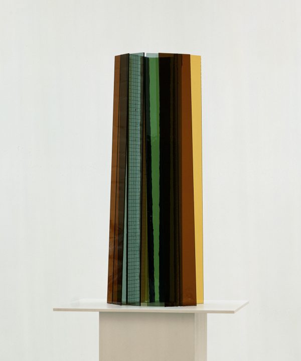 Planks of various materials assembled into a cylinder on a white pedestal
