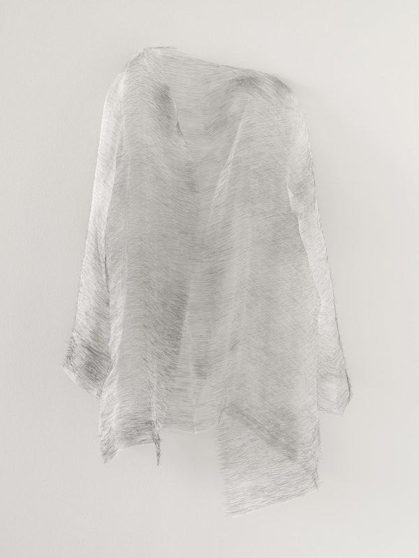 A piece of nearly translucent gray cloth hangs effortlessly off the wall in a shape reminiscent of a ghost.