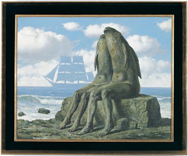 Two creatures with human legs and fish heads nestle together while seated on a stone by the seashore.