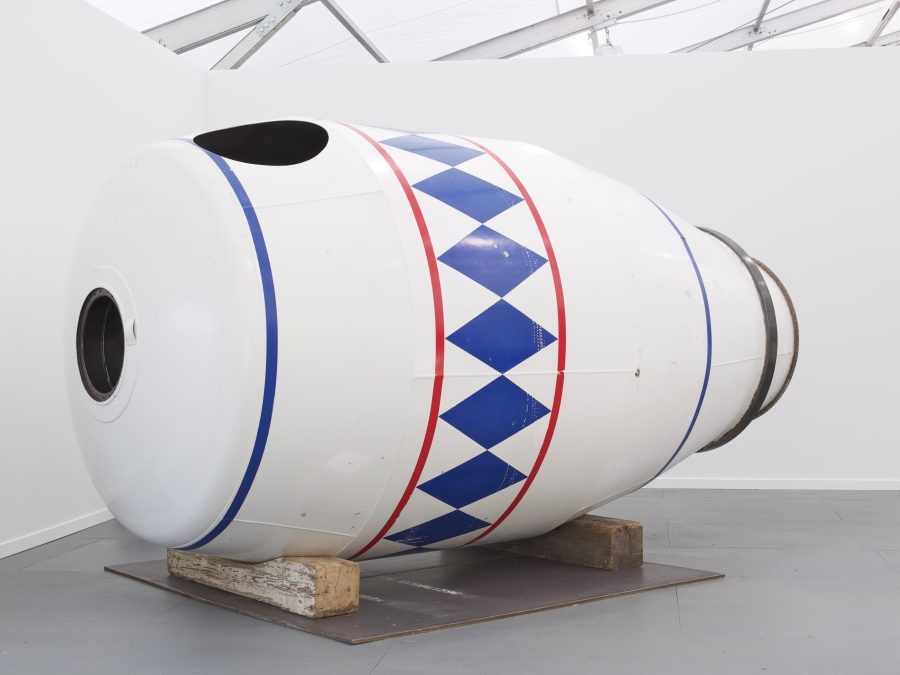 An installation view of a large white container decorated with red and blue designs