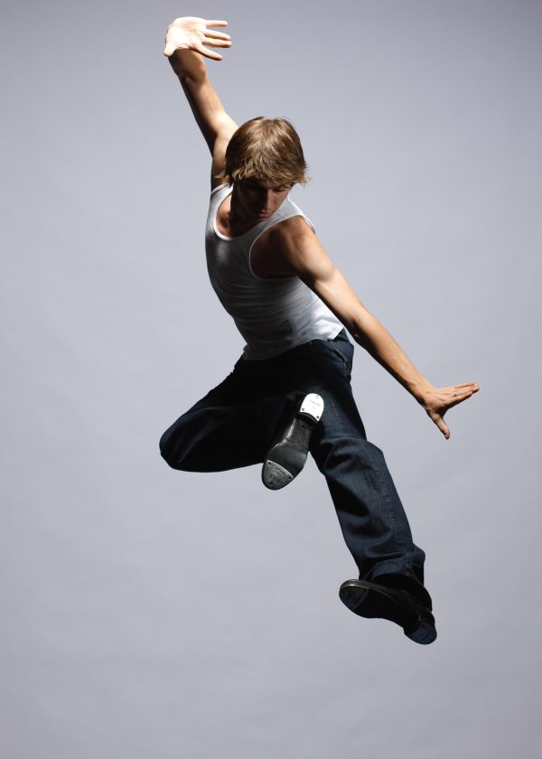 An action photograph captures a performer dancing midair.