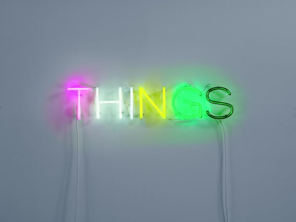 A glowing neon-light sculpture spells out the word 
