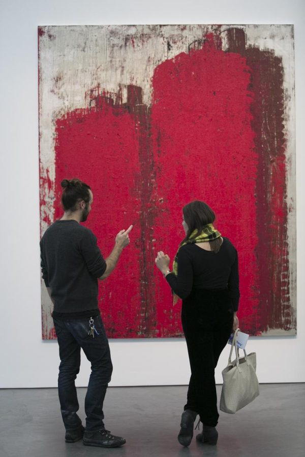 A man and woman look at a painting