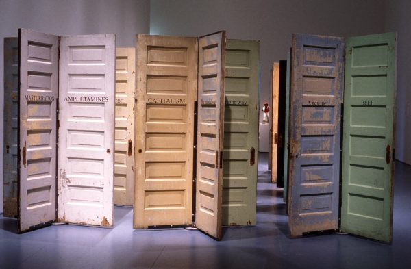A cluster of pastel-colored doors with peeling paint. Each is labeled with a one-word term, including, 