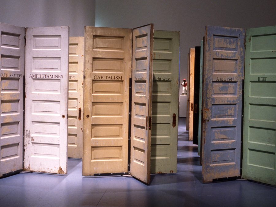 A cluster of pastel-colored doors with peeling paint. Each is labeled with a one-word term, including, 