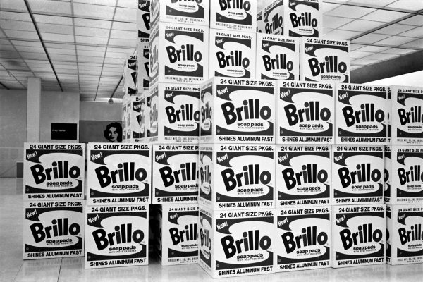 A black-and-white photo of a bunch of big boxes stacked together all the way to the ceiling.