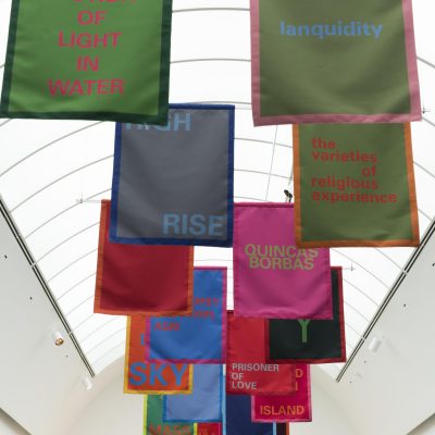 Colorful banners hang in pairs from the ceiling. Each one features a text, for example,