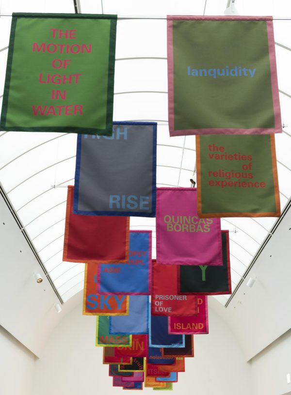 Colorful banners hang in pairs from the ceiling. Each one features a text, for example, 