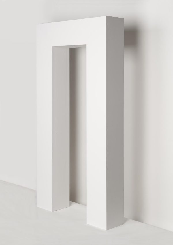 A white, angular archway against a white wall
