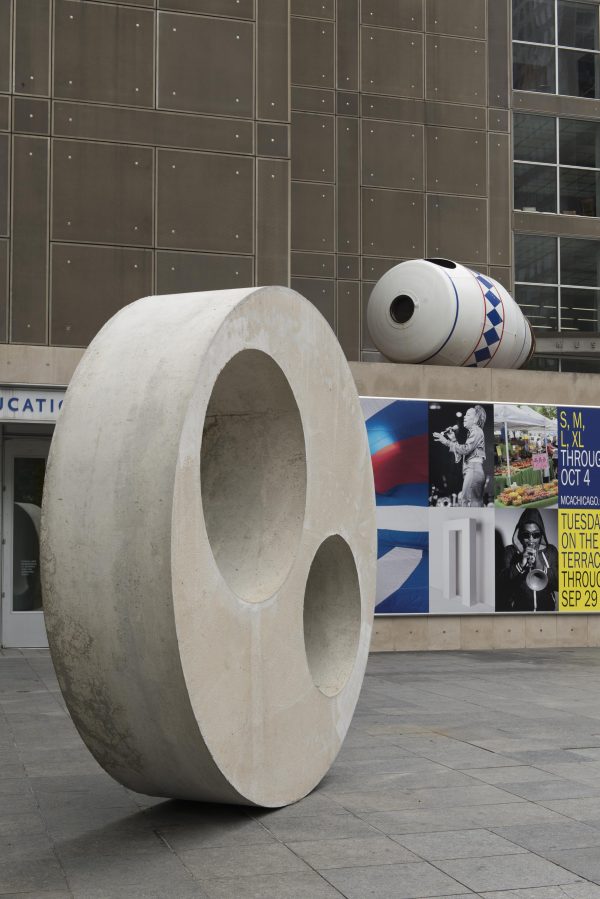 Close-up of a large concrete disc and a white container-shaped sculpture on the MCA Plaza