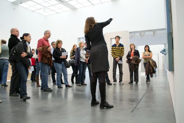 A guide leads a large group through an MCA exhibition.