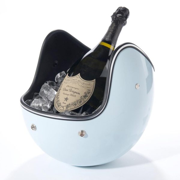 A light-blue motorcycle helmet balances upside-down, filled with ice and a bottle of champagne.