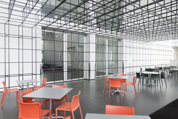 MCA Cafe with chairs and tables and a ceiling plane made of grey, open-sided cubes that semlessly transitions into a grid of illusionistic cubes on the wall