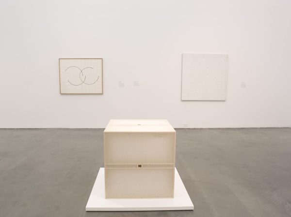 A gallery view with minimalist artworks on the walls and floor