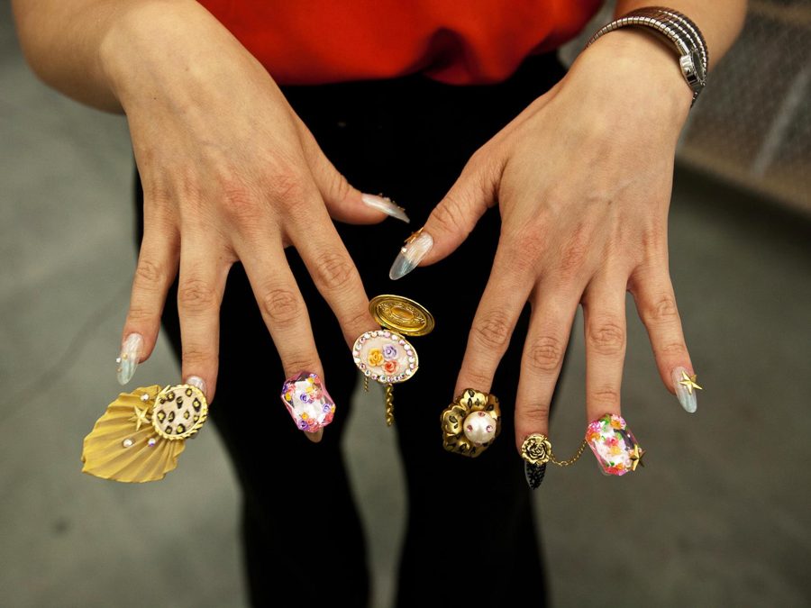 A set of hands with fingers splayed to reveal each intricate design and accessory adorning each fingernail