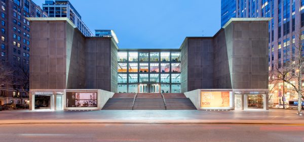 The MCA building with all four rows of windows lit up.