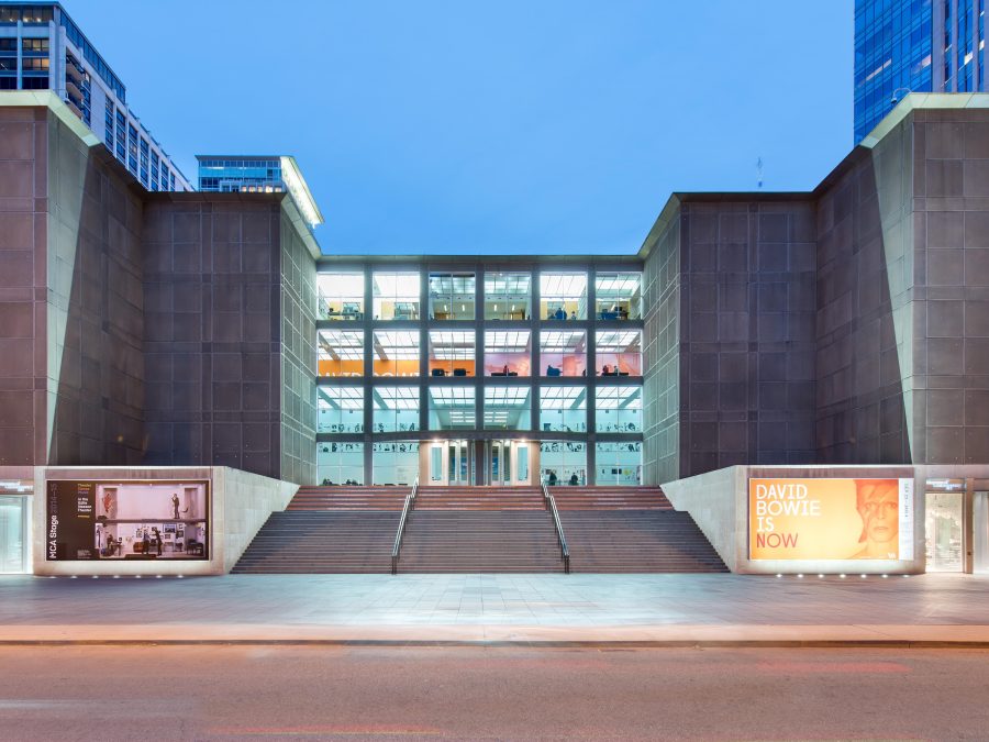 The MCA building with all four rows of windows lit up.