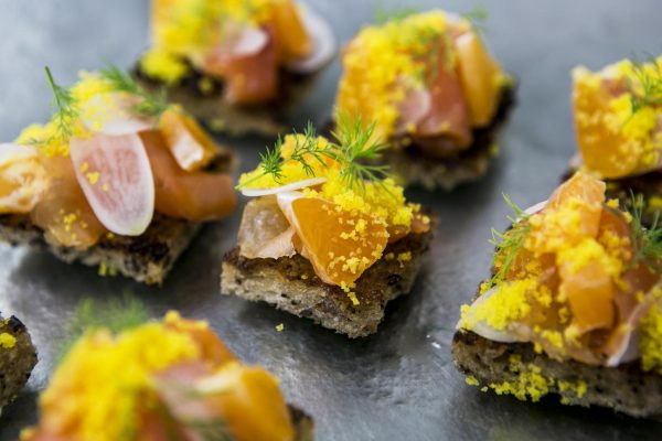 Clsoe up of tiny appetizers on squares of bread