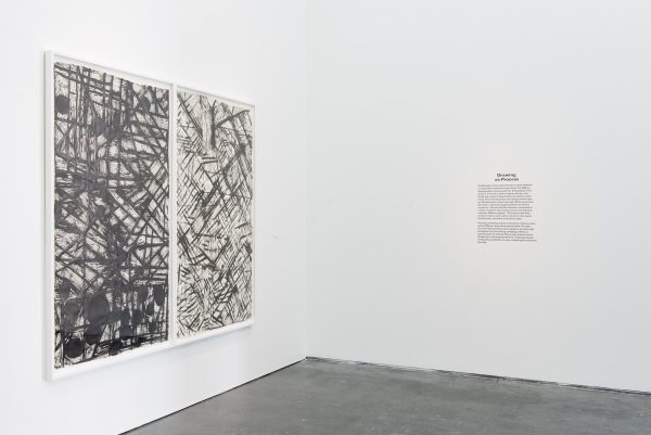 Two black and white abstract paintings on a gallery wall