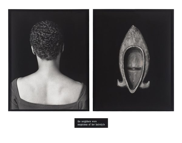 Two framed black and white pictures. The one on the left features a portrait with the person's back turned toward the viewer; the right image is of the back of a wooden mask. A small plaque appears under the frames.