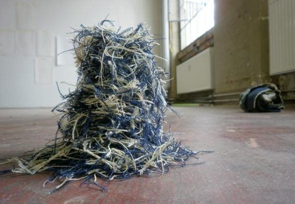 A pile of blue and white threads on a floor of an old building