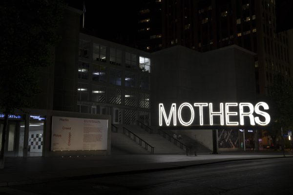 A large white neon sign reads MOTHERS at night in front of the MCA