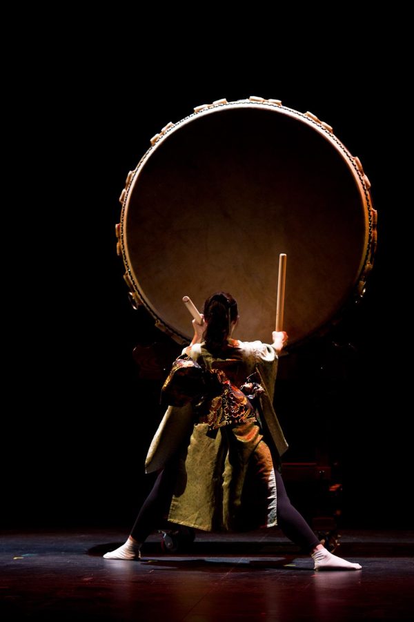 Dramatic image of a person facing a giant drum that is seemingly suspended in air