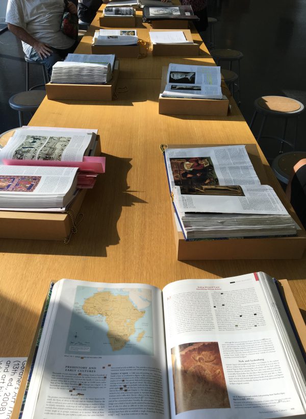 A wooden table filled with open books