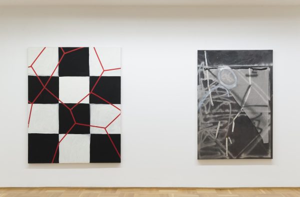 Two large vertical canvases featuring abstract works hang on a white wall