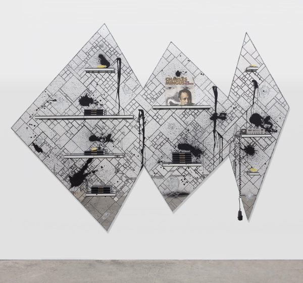 Three geometrically arranged diamond-shaped panels made up of tiled glass in various size rectangles and squares featuring shelves with piles of books on them, a Charles Mingus album, and an A-B radio. The whole thing is splattered with black.