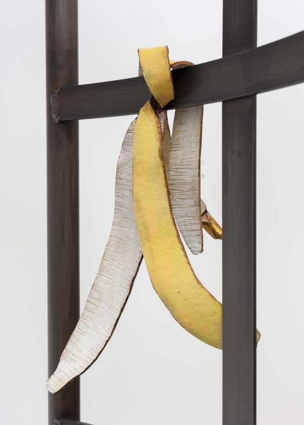 A close-up image shows a steel frame with a banana peel hanging off of it.