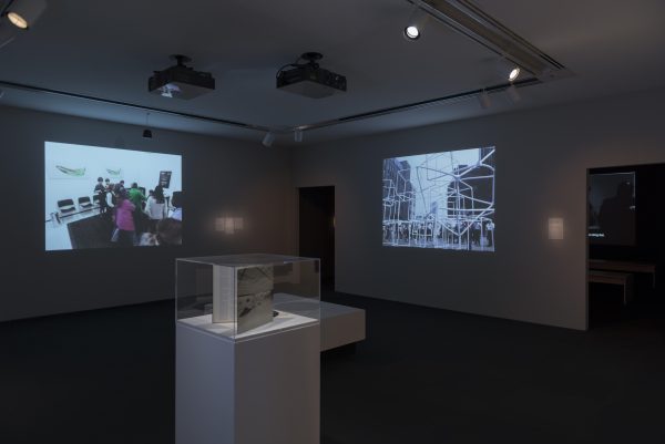 darkened gallery showing two projections on perpendicular walls