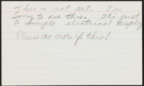 A ruled index card with cursive text reads 