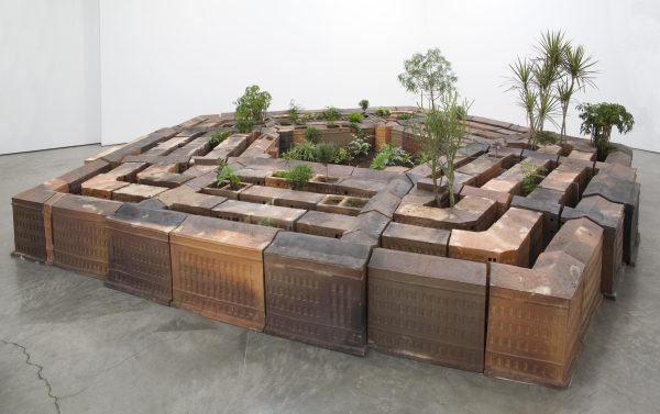 A ceramic model resembles the United States government building the Pentagon, with plants emerging from the alleyways and center open-air space.