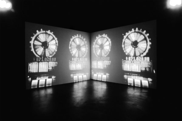 A mirrored image cast on two screens in a dark room